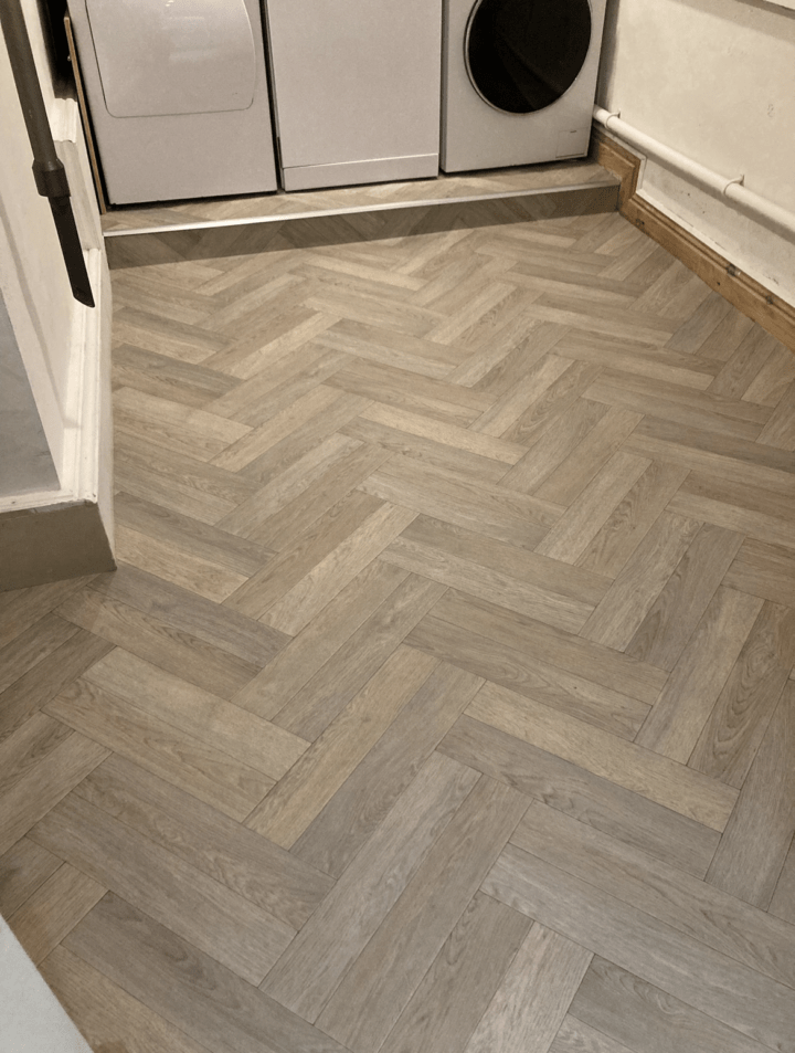 Herringbone hardwood flooring in utility room